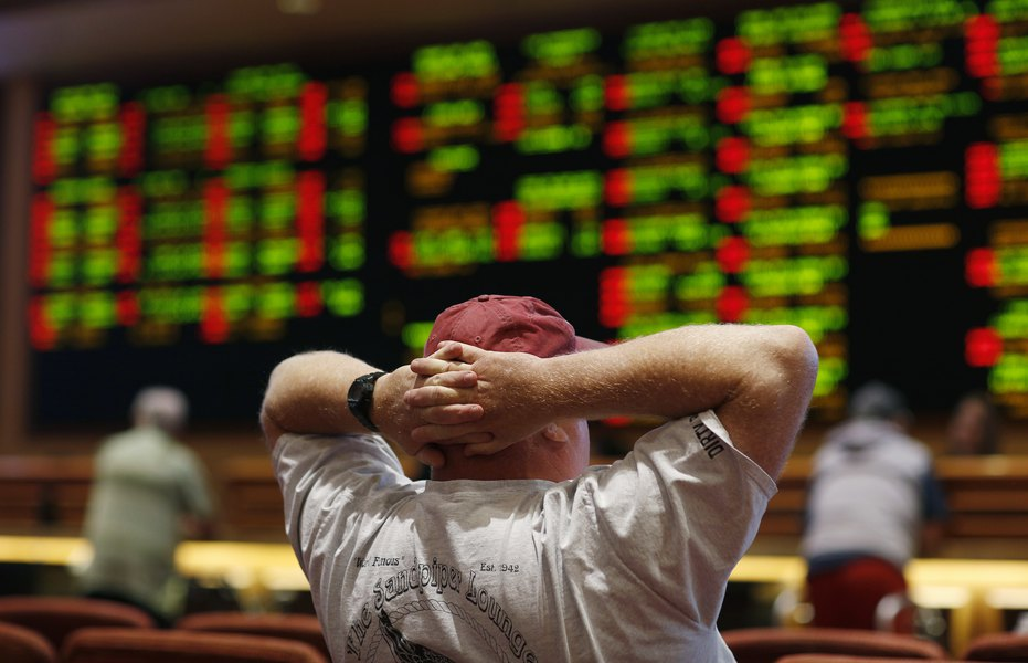 Photo of a man watching a sports betting board.